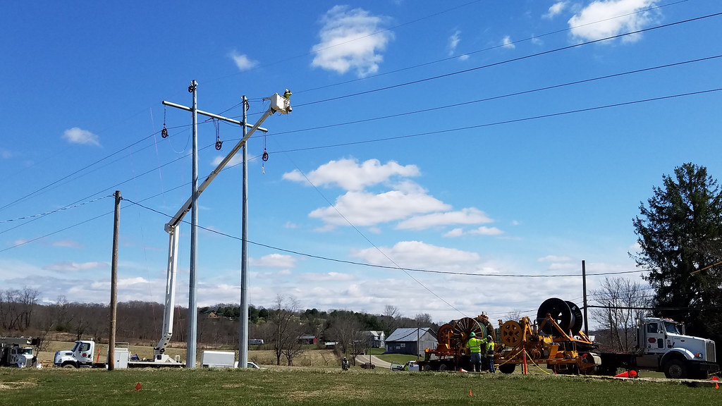 High voltage power lines against a blue sky